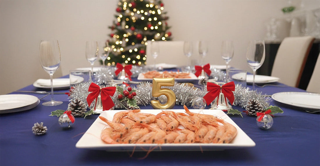 Una mesa elegante con una vela dorada de celebración de 5º aniversario, un plato de marisco y decoración de navidad elegante.