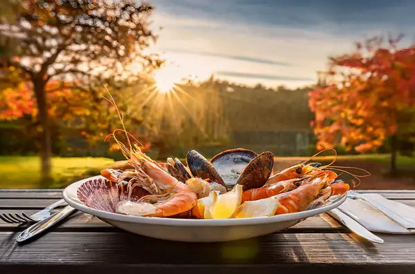 Plato de mariscos frescos en una mesa de un jardín en otoño